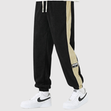 Denis – Sportovní kalhoty s kontrastními pruhy" can be rewritten as:

"Denis – Sportovní kalhoty s výraznými kontrastními pruhy