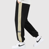 Denis – Sportovní kalhoty s kontrastními pruhy" can be rewritten as "Denis – Sportovní kalhoty s výraznými pruhy.